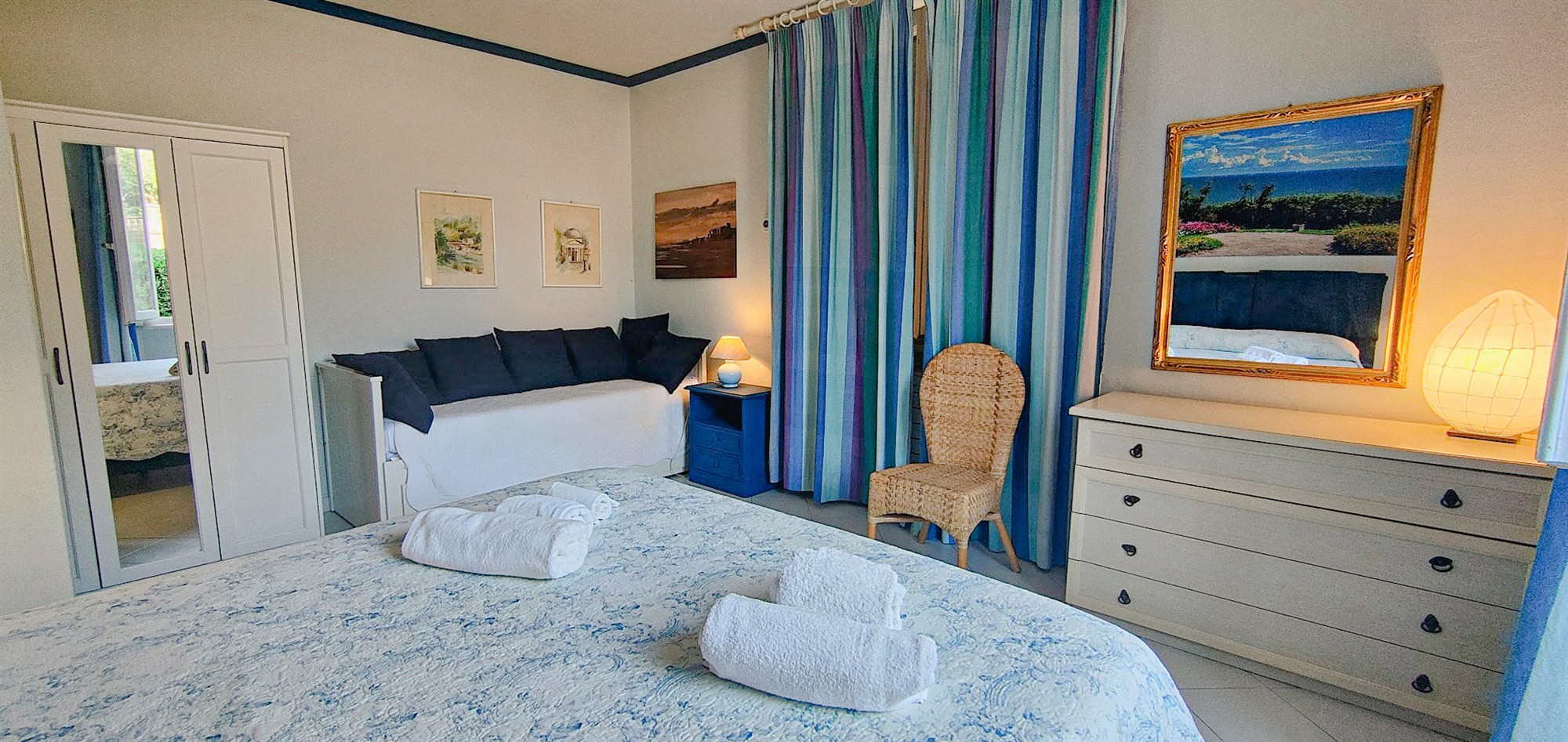 Chambre double avec mobilier bleu et fenêtre